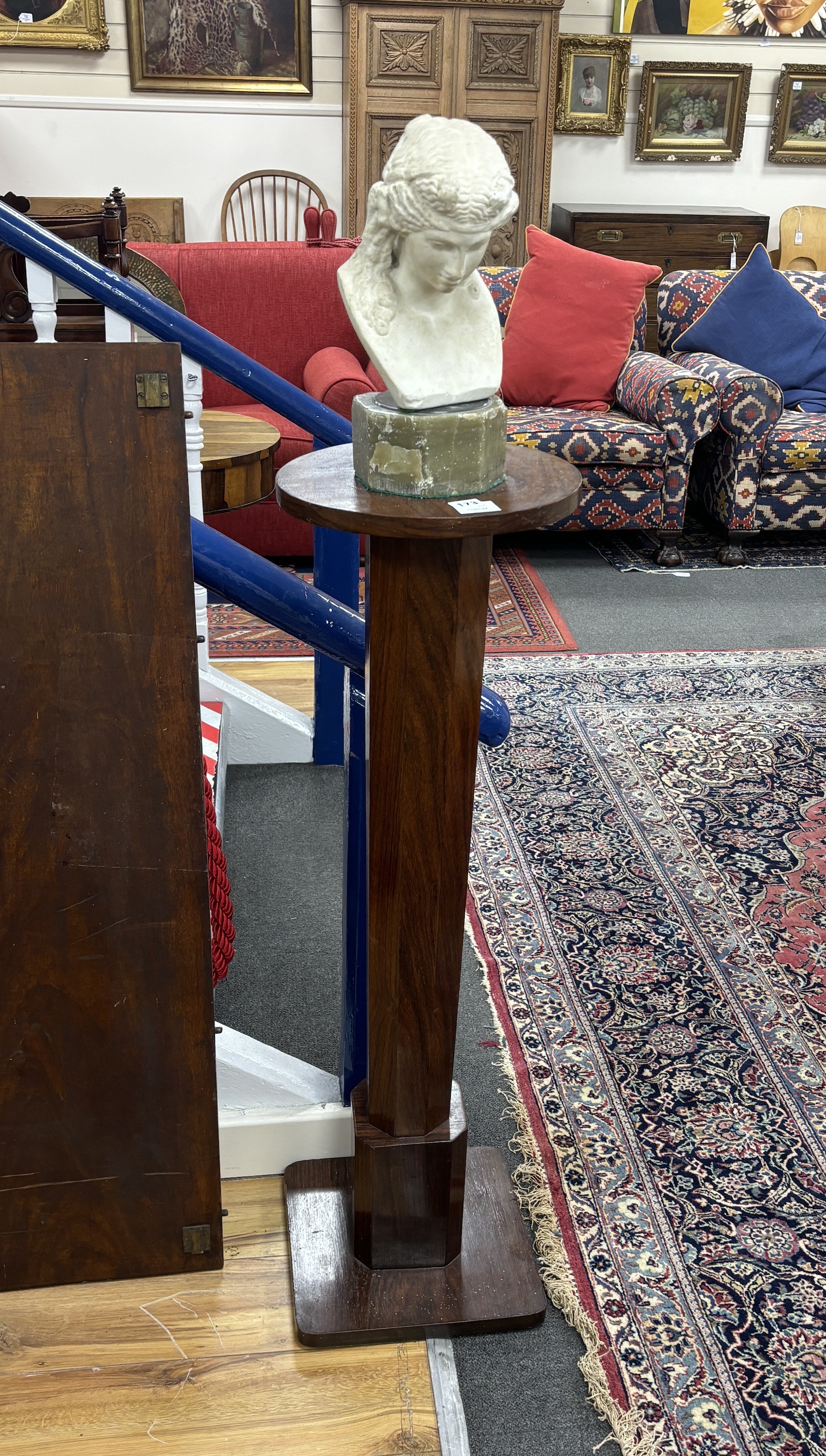 After the Antique, a carved marble bust of a young woman on octagonal onyx plinth and rosewood pedestal, combined height 142cm